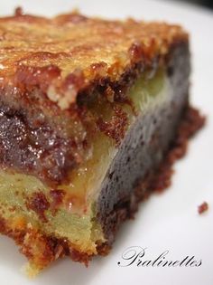 a piece of cake sitting on top of a white plate with chocolate and cream topping