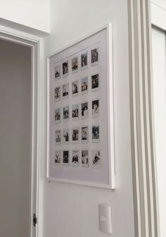 a white framed photo hanging on the wall next to a door with striped curtains in front of it