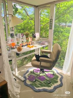 a room with a table, chair and window in it that has an area rug on the floor