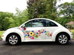 a white car with colorful flowers painted on it's side