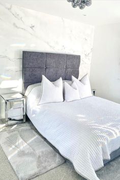 a bedroom with marble walls and white bedding