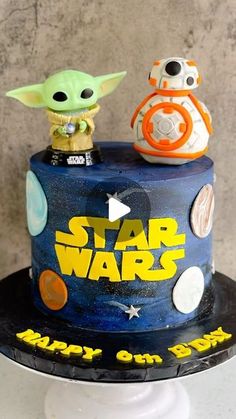 a star wars themed birthday cake with two toy figures on top