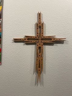 a wooden cross hanging from the side of a wall