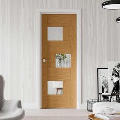 a living room filled with furniture and a wooden door next to a white wallpapered wall