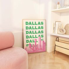 a pink couch sitting next to a white wall in a living room with a framed poster on the wall