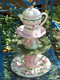 three tiered plates stacked on top of each other in the shape of tea cups