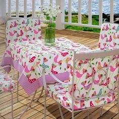 a table and chairs on a deck with water in the background