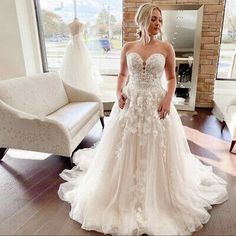 a woman standing in front of a wedding dress