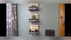 three wooden boxes with plants in them hanging on the wall