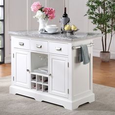 a white kitchen island with marble top and drawers