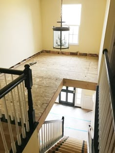 an empty room with stairs leading up to the second floor and a window on the far wall