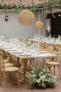 the tables are set with white flowers and place settings for an elegant dinner party or reception