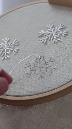 someone is stitching snowflakes on the fabric