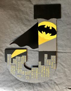 the letter j is made out of cardboard and has batman symbols on it