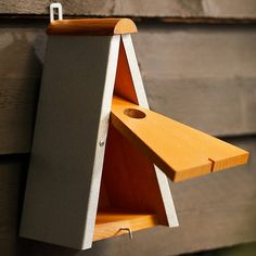 a bird house hanging on the side of a building