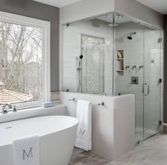 a large white bath tub sitting next to a window