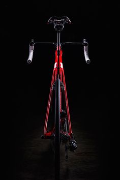 the front end of a red bicycle in the dark