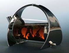 a fire place sitting on top of a table next to a glass vase with people in it