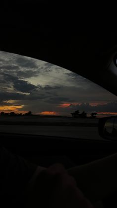 the sun is setting in the distance as seen from inside a car