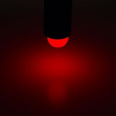 a red light is shining in the dark room with only one light on it's side