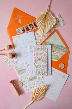 an assortment of wedding stationery items on a pink background