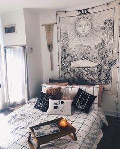 a bedroom with a large tapestry hanging above the bed and pillows on the side table