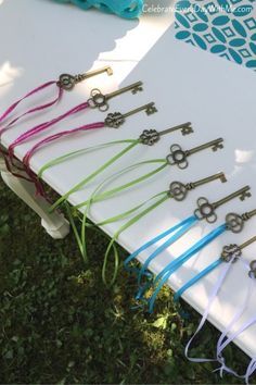 a bunch of keys sitting on top of a white board next to green grass and blue flowers