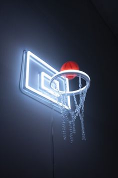 an illuminated basketball hoop with a red ball on it