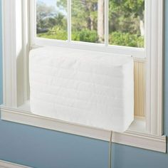 a white mattress sitting on top of a window sill in front of a blue wall