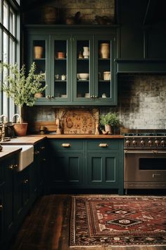 a kitchen with dark green cabinets and wooden floors, an area rug on the floor