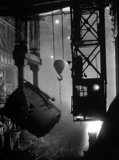 an old black and white photo of machinery in a factory with steam pouring out of it