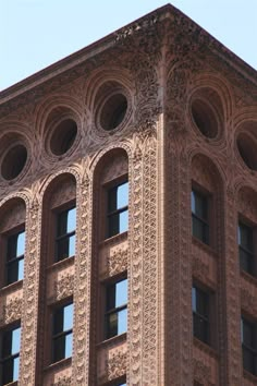 the top of a tall building with ornate designs on it's sides and windows