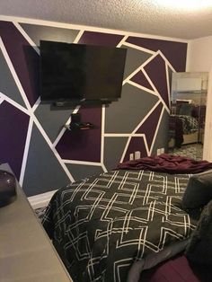 a bed room with a neatly made bed and a flat screen tv on the wall