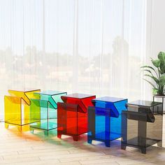 there are four different colored glass tables in this room, one is black and the other is multicolored