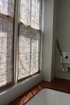 a bathroom with a sink, window and towel rack in front of the bathtub