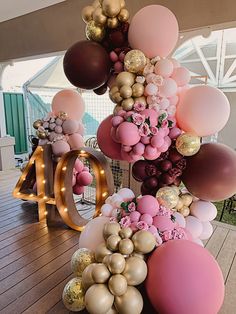 the balloon arch is decorated with pink, gold and white balloons that spell out 40