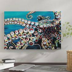 an octopus painting hanging on the wall above a desk