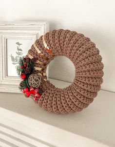 a wreath is hanging on the mantle next to a frame