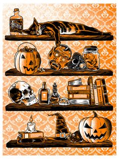 a cat laying on top of a wooden shelf filled with halloween decorations and pumpkins