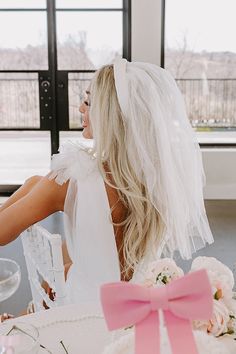 a woman sitting at a table with a veil on her head