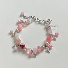 "Handmade Dreamy Bracelet ✿ Made with glass crystal beads, Quartz, rose Quartz, freshwater pearls, glass beads, and metal accents ✿ Colors: Silver, a multitude of pinks, blush pink, icy pink, pearlescent pink, milky white. maroon, iridescent clear, pearlescent white, and iridescent clear ✿ The bracelet has an additional 1-1.5\" of extension chain" Elegant Pink Beaded Bracelets With Heart Beads, Pink Pearl Beaded Bracelets For Jewelry Making, Rose Quartz Bracelet Aesthetic, Handmade Rose Quartz Beaded Bracelets, Pink Beaded Crystal Bracelet For Valentine's Day, Feminine Pink Pearl Bracelets, Handmade Pink Glass Bracelets, Pink Beaded Kawaii Bracelets, Pink Pearl Charm Bracelet