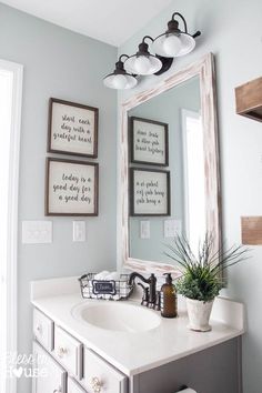 a bathroom with a sink, mirror and pictures on the wall above it's vanity