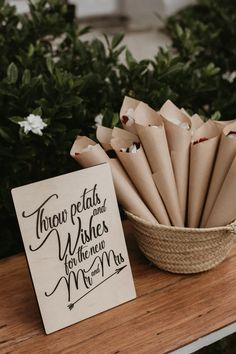 there is a basket full of paper flowers next to a sign that says throw petals and wishes for the newly married couple