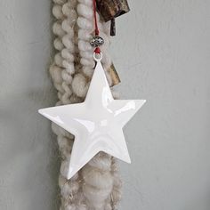 a white star ornament hanging from a rope