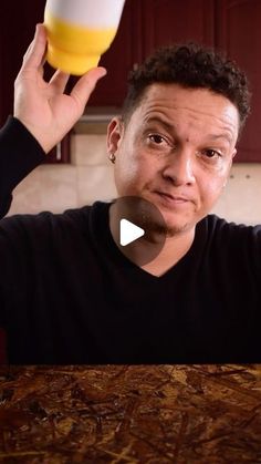 a man holding up a beer in front of his face