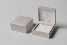 an open box with a watch inside on a gray surface next to it's packaging