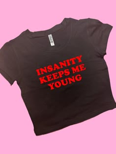 Insanity Keeps Me Young SNUG FIT Crop Top | Crop Top | Graphic Top | Gift For Her | Y2K  Tee | Y2K crop top | Gift for friend | Baby Tee Comfy Top to Lounge in! Actual item may be lighter/darker than pictured. M A T E R I A L S - SNUG FIT - 100% RING SPUN COTTON - Shoulder Taping S I Z I N G - Size chart is available on our listing photos. S H I P P I N G  &  P R O D U C T I O N  T I M E - Production Time is 5 Business Days. (May be delayed during the Holiday Season) - Shipping Time is 2-6 Busin Y2k Style Text Print Crop Top T-shirt, Y2k Style Crop Top T-shirt With Text Print, Y2k Text Print Cropped T-shirt, Y2k Cropped T-shirt With Slogan, Fitted Y2k Cropped T-shirt With Slogan, Funny Crop Tops, Goofy Shirt, Sarcastic Clothing, Funky Shirts