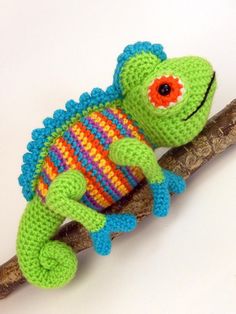 a crocheted lizard sitting on top of a branch