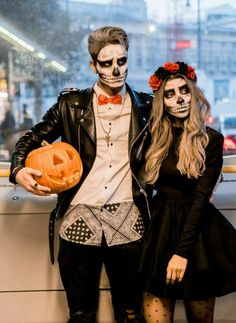 a man and woman dressed up as skeletones posing for a photo in front of a window