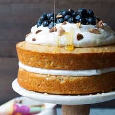 a cake with white frosting and blueberries on top